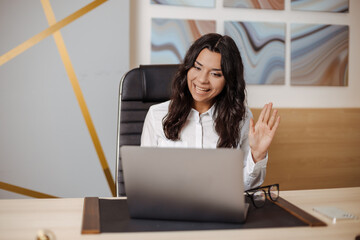 Happy young indian or arabic business woman having online meeting at the office by laptop