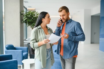 Two business coworkers walking through a lobby of an office building