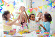 © famveldman - Kids birthday party. Children with cake and gifts