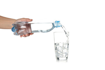 Wall Mural - Female hand pour water in glass from bottle, isolated on white background