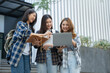 © crizzystudio - Asian female college students look at and study insights and biology on a laptop and record in a notebook at the outside university.