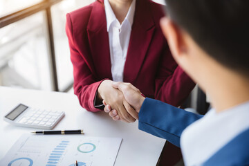 Business men and women shake hands confidently professional investor working with new startup project at an office meeting.