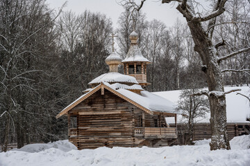 Wall Mural - old houses and household buildings made of wooden beams according to old technologies in the vicinity of Veliky Novgorod in winter