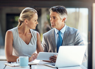 Poster - Hmm, maybe that could work. a mature business couple looking thoughtfully at each other in the office while planning their next move.
