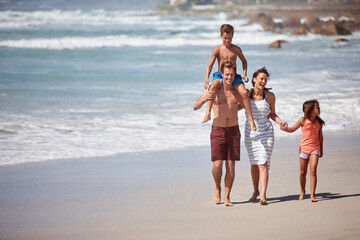 Canvas Print - The perfect family getaway. a family walking along the beach.