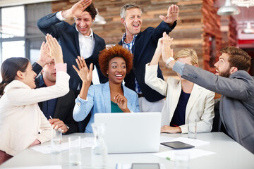 Canvas Print - Another successful design project. A group of designers celebrating good news while working together at a laptop.