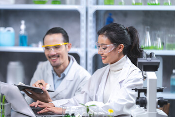 Wall Mural - Pharmaceutical factory woman worker in protective clothing operating production line in sterile environment, scientist with glasses and gloves checking hemp plants in a marijuana farm