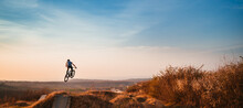 Young Man On A Mountain Bike Performing A Dirt Jump