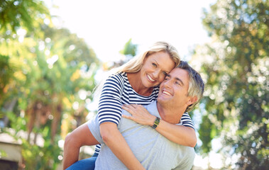 Poster - He means the world to me. Cropped portrait of an attractive mature woman on her husbands back in the park.