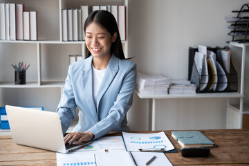Poster - Beautiful Asian businesswoman typing on laptop computer while working in the modern office room.