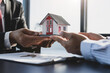 Real estate inheritance concept and contract agreement. The real estate agent offers the customer a model home after the legal purchase of the home is signed.