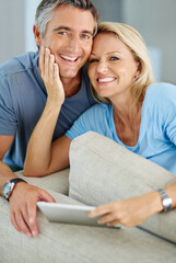 Poster - We always make the most of our time together. Portrait of a smiling couple sitting at home using a digital tablet.