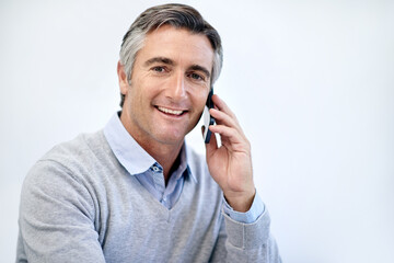Poster - Staying in touch with his clients. a mature businessman talking on his cellphone.