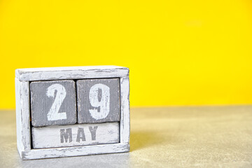 May 29 calendar made wooden cubes yellow background.With an empty space for your text.