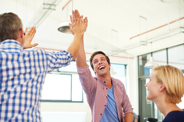 Poster - The key to success is hardwork and determination. a group of designer high-fiving each other during an informal meeting.