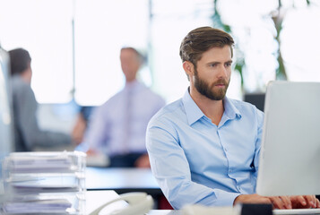 Aufkleber - Driven to succeed. a handsome young businessman working at his office computer.