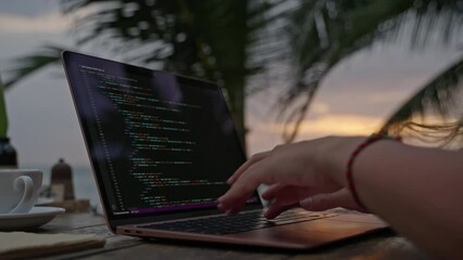 Female developer working on laptop by the ocean. Young woman freelancer coding at outdoor tropical cafe. Caucasian girl working remotely typing on computer at exotic location close-up. Worldwide work.