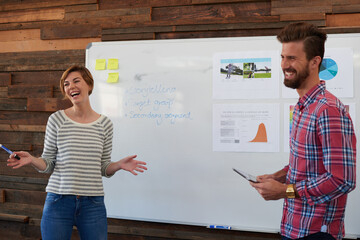 Aufkleber - Theyve got their thinking caps on. two young designers brainstorming at a whiteboard.