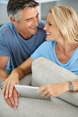 Poster - Sharing a little laugh online. a smiling couple sitting at home using a digital tablet.