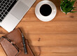 cup of coffee, laptop, pen, glasses on a wooden background
