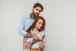 © alones - Fashion beautiful lovers couple in the studio. Pretty redhead woman and handsome hipster man with tattoos hug on a white background