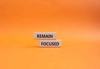 Remain focused symbol. Concept words Remain focused on wooden blocks. Beautiful orange background. Business and Remain focused concept. Copy space.