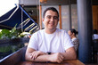 © Arvin - Hombre Latino blanco moreno con una playera blanca en un restaurante disfrutando la vista