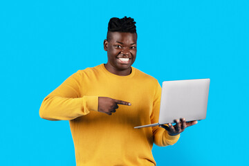 Wall Mural - Portrait Of Cheerful Young Black Man Pointing At Laptop In His Hands