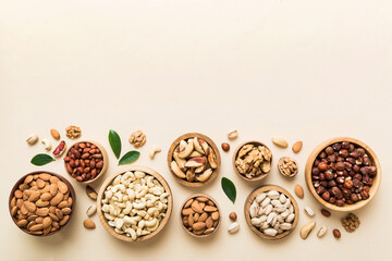 mixed nuts in wooden bowl. mix of various nuts on colored background. pistachios, cashews, walnuts, 