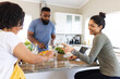 © Wavebreak Media - Happy diverse friends cooking together in kitchen, drinking wine