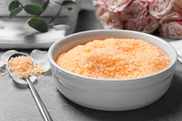 Beautiful spa composition with sea salt and flowers on grey table, closeup