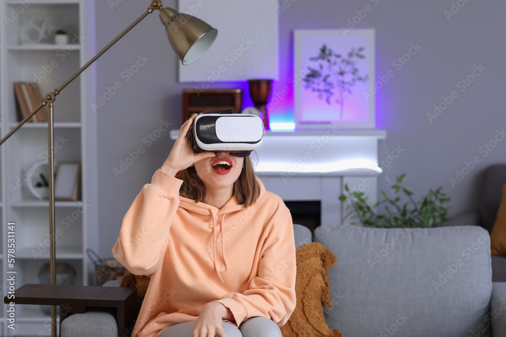 Pretty young woman in VR glasses at home