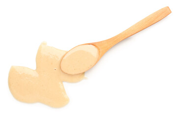 Wall Mural - Wooden spoon with tasty tahini on white background