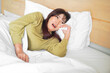 © Reezky - A sad young Asian woman is crying while lying on the bed