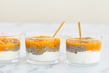 Wall Mural - Chia pudding with passion fruit and coconut yogurt in glass. Healthy vegan recipe.