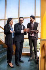 Wall Mural - Indian businesspeople using laptop and discussing at office.