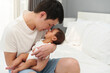 © geargodz - father kissing his newborn baby on bed