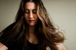 © Cavan Images - Woman sitting and her hair is moving