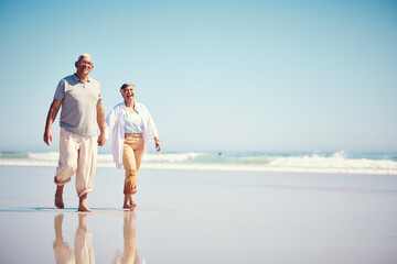 Wall Mural - Holding hands, summer and an old couple walking on the beach with a blue sky mockup background. Love, romance or mock up with a senior man and woman taking a walk on the sand by the ocean or sea