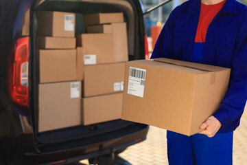 Canvas Print - Courier with parcel near delivery van outdoors, closeup. Space for text