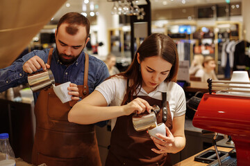 A man and a girl make coffee at a coffee machine in a coffee shop