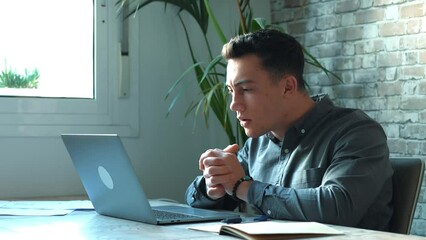 Unhappy young caucasian male worker in glasses look at laptop screen shocked by gadget breakdown or operational problems. Frustrated man confused surprised by unexpected error on computer device.
