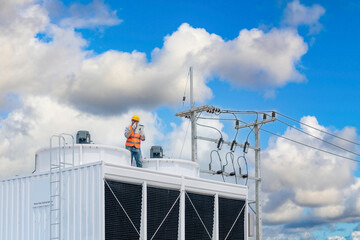 Wall Mural - Industry engineer under checking the industry cooling tower air conditioner is water cooling tower air chiller HVAC of large industrial building to control air system.