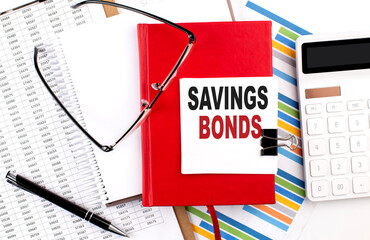 Poster - SAVING BONDS text on notebook with chart, calculator and pen