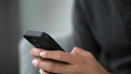 The man hand is typing on the mobile phone screen.