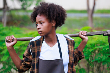 Wall Mural - portrait of young african black girl. Little african american child girls standing with shovel or spade in greenhouse farm