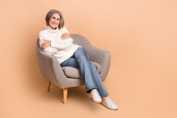 Sticker - Full length photo of pretty adorable woman wear knitted pullover hugging herself empty space isolated beige color background