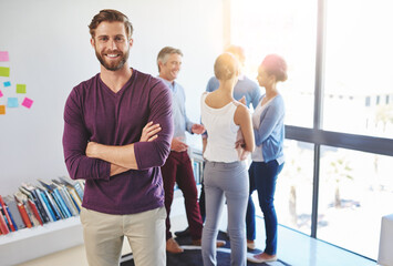 Poster - Proud to be a part of a vibrant team. Portrait of a young businessman with his colleagues standing in the background.