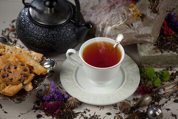 Wall Mural - Sweet, hot tea with dry tea leaves, on an old background.