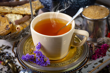 Wall Mural - Sweet, hot tea with dry tea leaves, on an old background.